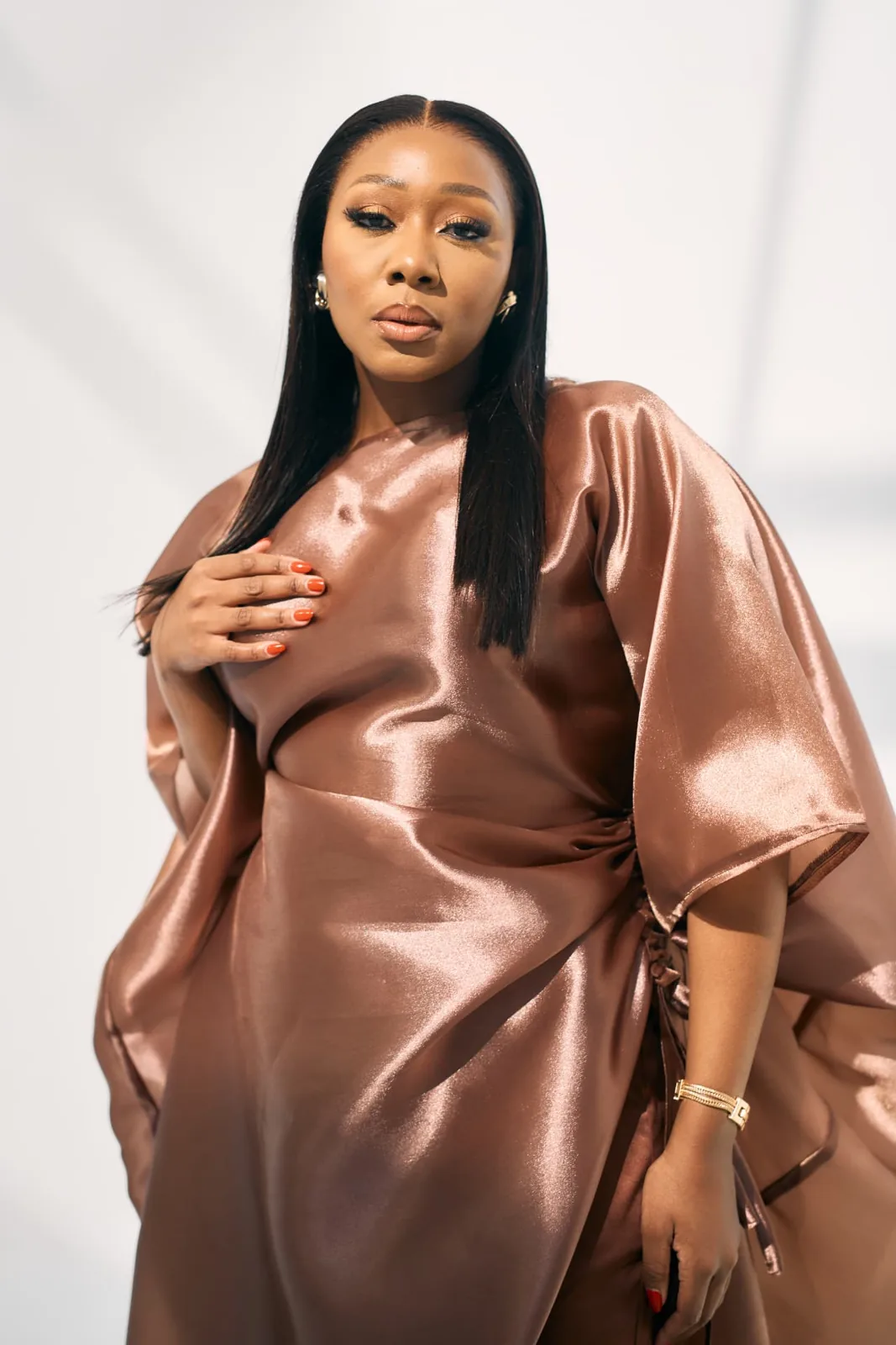 Lebo Lion in a rose gold satin gown, author of Audacity